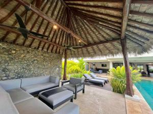 an outdoor patio with couches and a swimming pool at Naisoso Island Villas - Fiji in Nadi