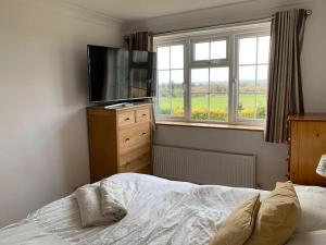 Schlafzimmer mit einem Bett und einem Flachbild-TV in der Unterkunft Lovekush Epsom Banstead Surrey. Views over London in Ewell