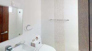 een badkamer met een wastafel, een toilet en een spiegel bij Soha suites I in Santiago de los Caballeros
