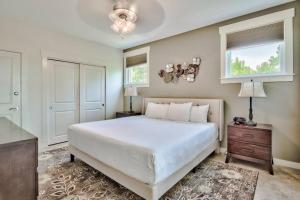 a bedroom with a large white bed and two windows at 3 bedroom Sandestin condo in Baytowne Wharf! in Destin