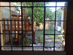 una ventana con vistas al jardín fuera de una casa en Casa Araucaria en Concepción del Uruguay