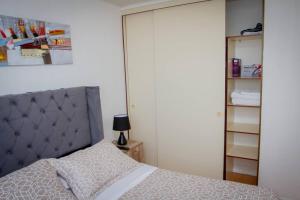 1 dormitorio con 1 cama con cabecero gris y armario en Quedate aqui Centro Concepcion I, en Concepción