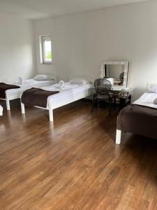 a room with three beds and a wooden floor at Hanja in Sarajevo