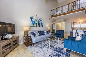 a living room with a couch and a tv at Sunshine At The Beach in Orange Beach