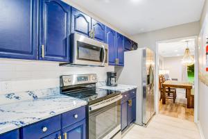 a kitchen with blue cabinets and a refrigerator at The Wilmington Condos Island in Savannah