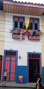 a little girl standing in front of a colorful building at Casa colonial filandia in Filandia
