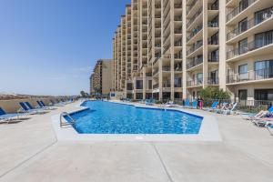 una piscina frente a un gran edificio de apartamentos en Phoenix V 1512, en Orange Beach