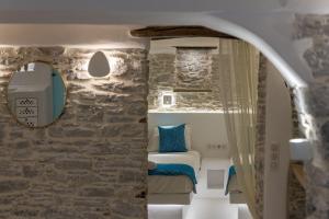a bedroom with a bed in a stone wall at Margaret's Houses in TINOS Town in Tinos Town +49 photos