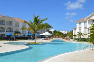 a resort swimming pool with a hotel in the background at Apartment in Cadaques Caribe in Bayahibe