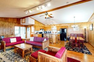 a living room with wooden walls and red furniture at Pirate's Light #73-B in Buxton