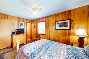 a bedroom with wooden walls and a bed and a television at Pirate's Light #73-B in Buxton