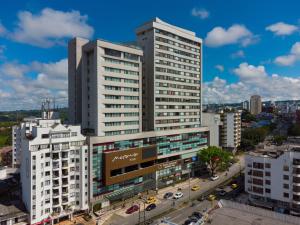 een hoog wit gebouw met auto's in een stad bij Hotel Mocawa Plaza Armenia in Armenia