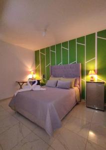 1 dormitorio con 1 cama grande y paredes verdes en Kay Amazon Lodge, en Sauce