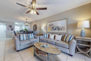 a living room with two couches and a table at Seaside Beach & Racquet Club 3602 in Orange Beach