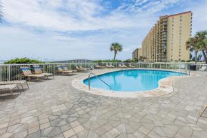 a swimming pool with patio furniture and a building at Seaside Beach & Racquet Club 3602 in Orange Beach