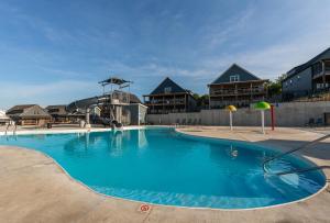 una gran piscina con edificios en el fondo en Brand New! Lake View with Arcade Game Room! Fully stocked kitchen!, en Hollister