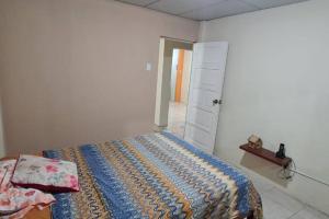 1 dormitorio con 1 cama y puerta abierta en For travelers / Entire Home in Guayaquil, en Guayaquil