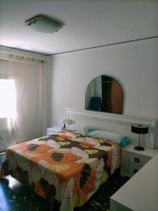 um quarto com uma cama e um espelho na parede em Apartamento Bellas Vistas. em El Verger