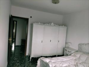 um quarto com uma cama e um armário branco em Apartamento Bellas Vistas. em El Verger