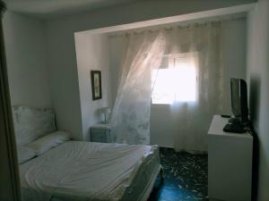 um quarto com uma cama, uma janela e uma televisão em Apartamento Bellas Vistas. em El Verger