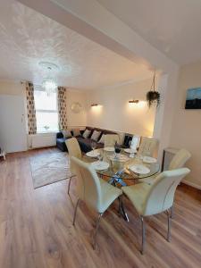 a living room with a table and chairs and a couch at Elegant and central two bedrooms house in Bristol