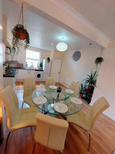 ein Esszimmer mit einem Glastisch und gelben Stühlen in der Unterkunft Elegant and central two bedrooms house in Bristol