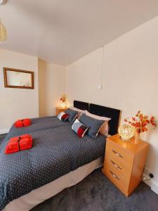 ein Schlafzimmer mit einem großen Bett und einer Holzkommode in der Unterkunft Elegant and central two bedrooms house in Bristol