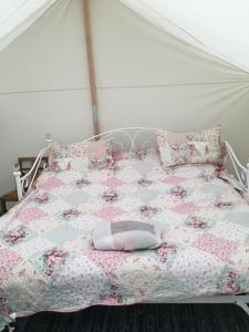 a bed with a pink quilt and pillows on it at Amelia Vera in Lincolnshire