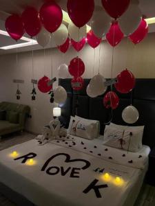Habitación con cama con globos rojos y blancos en فندق نواة المدينة en Abyār ‘Alī