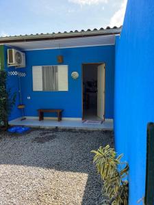 a blue house with a bench in a yard at Chalés Caminhos do Cacau Camburi in Sao Paulo +14 photos