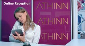 a woman looking at a tablet in front of a sign at AthINN Residence in Athens