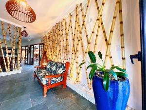 a living room with a chair and a potted plant at Pousada NAAN Lázaro Ubatuba in Ubatuba