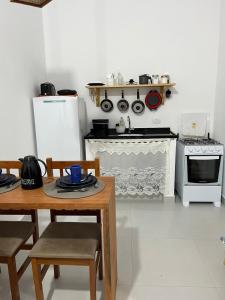 a small kitchen with a table and a stove at Chalés Caminhos do Cacau Camburi in Sao Paulo