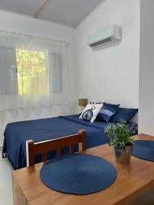 a bedroom with a bed and a table with a blue blanket at Chalés Caminhos do Cacau Camburi in Sao Paulo