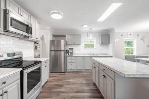 uma grande cozinha com armários brancos e electrodomésticos de aço inoxidável em Madison Family Home & Event Rental Space on 7 Private Acers em Madison