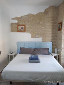 1 dormitorio con 1 cama blanca grande y 2 mesas en Vivienda Turística Templo Romano en Córdoba