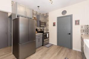 a kitchen with stainless steel appliances and a black refrigerator at LA CASITA DEL REY in Puerto Peñasco