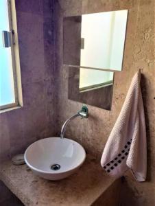 bagno con lavandino bianco e specchio di Casa em Interlagos a Camaçari