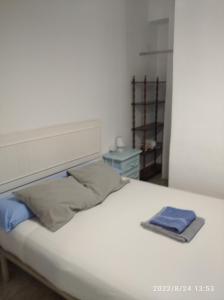 - un lit blanc avec 2 serviettes dans l'établissement Vivienda Turística Templo Romano, à Cordoue