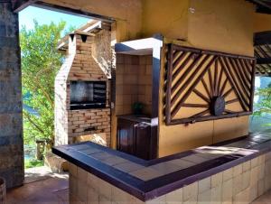 una cucina all'aperto con griglia e un forno in mattoni di Casa em Interlagos a Camaçari