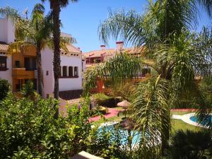 una vista de una casa con palmeras y una piscina en Marina Esuri Golf y Playa, en Ayamonte