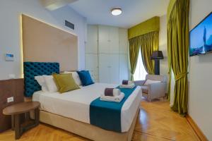 sypialnia z dużym łóżkiem i krzesłem w obiekcie AthINN Residence w Atenach