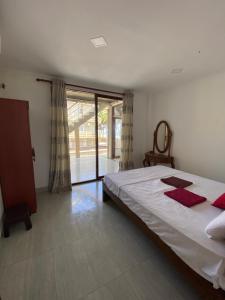 ein Schlafzimmer mit einem großen Bett und einem großen Fenster in der Unterkunft Oasis Beach Villa in Kalutara