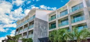 a white building with palm trees in front of it at Jeju Resort in Jeju