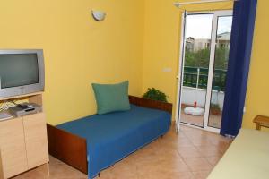 ein Wohnzimmer mit einem Sofa und einem TV in der Unterkunft Apartments by the sea Promajna, Makarska - 2642 in Promajna