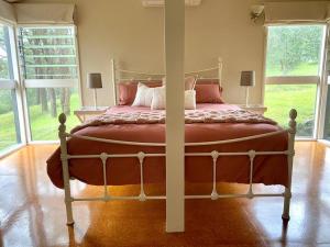 1 dormitorio con 1 cama grande en una habitación con ventanas en Dungog Farmstay - Kingaley, 