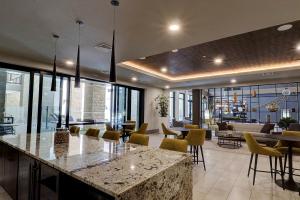 a lobby with a bar with yellow chairs and tables at Walk Score 81-Shopping District-King Bed-Parking - G4004 in Scottsdale