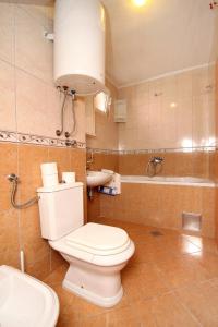 ein Badezimmer mit einem WC, einem Waschbecken und einer Badewanne in der Unterkunft Apartments by the sea Promajna, Makarska - 2674 in Promajna
