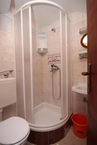 uma casa de banho com um chuveiro, um WC e um lavatório. em Apartments with a parking space Baska Voda, Makarska - 2609 em Baska Voda
