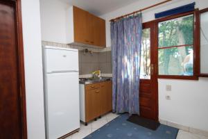 a kitchen with a white refrigerator and a window at Apartments with parking space Baska Voda, Makarska - 2609 in Baška Voda